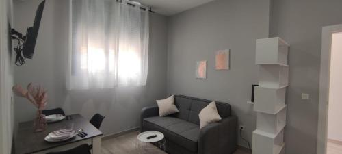 a living room with a couch and a table at Apartamentos Las trece llaves Jacuzzi bajo reserva in Merida