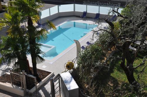 an overhead view of a swimming pool with a palm tree at Residence Paradise in Riva del Garda