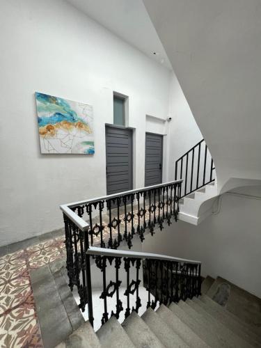 a staircase in a house with a painting on the wall at Nando's Place in San Juan