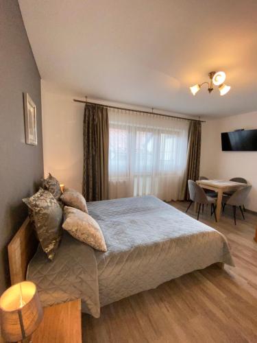 een slaapkamer met een bed en een eetkamer bij Domek Pod Lisem Szczawnica in Szczawnica