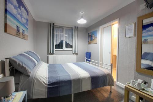 a bedroom with a bed and a window at The Rosslyn in Paignton