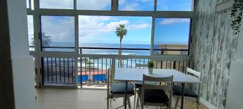 a view of the ocean from a balcony with a table and chairs at Kailani Tacoronte in Santa Cruz de Tenerife