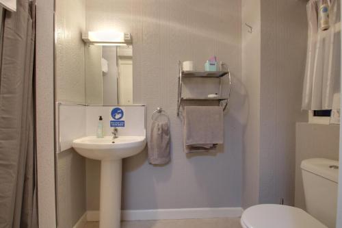 a small bathroom with a sink and a toilet at The Rosslyn in Paignton