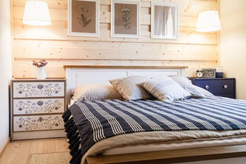 a bedroom with a bed and a wooden wall at ŠTVRTÁ VODA - Jánska chata in Liptovský Ján