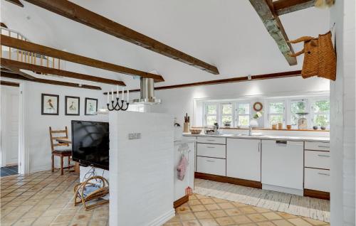 a kitchen with white cabinets and a flat screen tv at Amazing Home In Thisted With Wifi in Thisted
