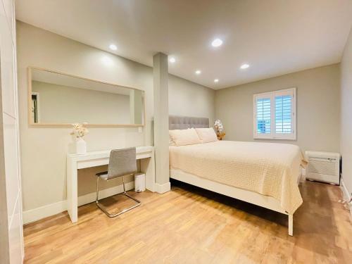 una camera con letto, scrivania e specchio di Lovely 1-bedroom walk on beach sand &free parking 10b a Los Angeles