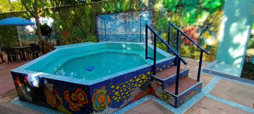 a jacuzzi tub in a room with a painting at Villa Margarita in Puerto Colombia