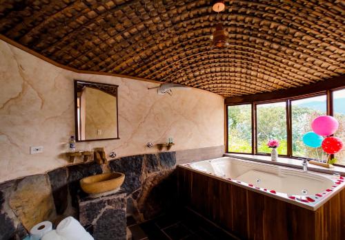 a bathroom with a tub and a toilet and balloons at Hotel Campestre La Periquera in Villa de Leyva