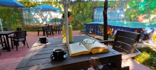 a wooden table with a book and glasses on it at Villa Margarita in Puerto Colombia
