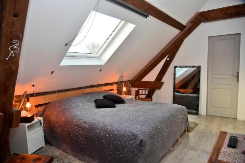 ein Schlafzimmer mit einem Bett und einem großen Fenster in der Unterkunft Les Colombines in Hombleux