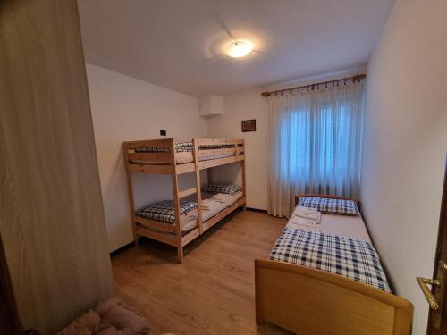 a small room with two bunk beds and a window at Stella alpina in Schilpario