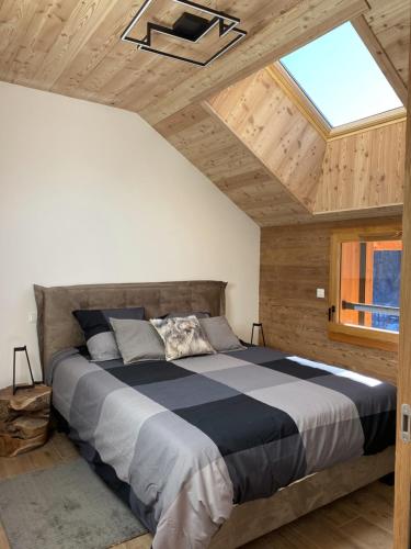 a bedroom with a large bed with a skylight at LE DOUX MELEZE in Saint-Chaffrey
