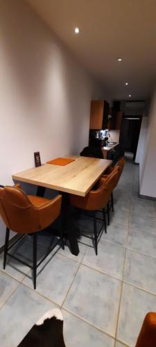 a wooden table and chairs in a room at Nez sur la croisette. in Dinant