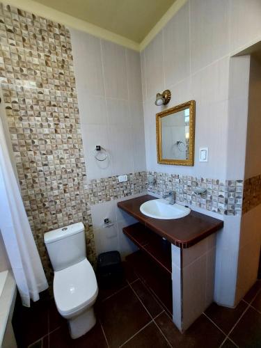a bathroom with a toilet and a sink at Ñaupa House Hostel in Cochabamba