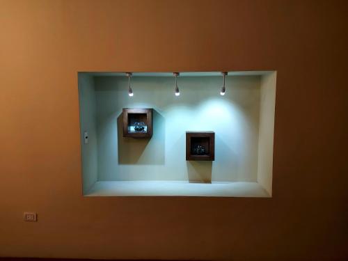a display case with two clocks in a wall at Ñaupa House Hostel in Cochabamba