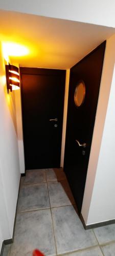 a bathroom with black doors and a tile floor at Nez sur la croisette. in Dinant