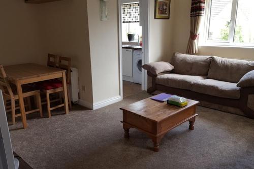 a living room with a couch and a coffee table at Lovely Cosy Apartment near Water Parks in South Cerney