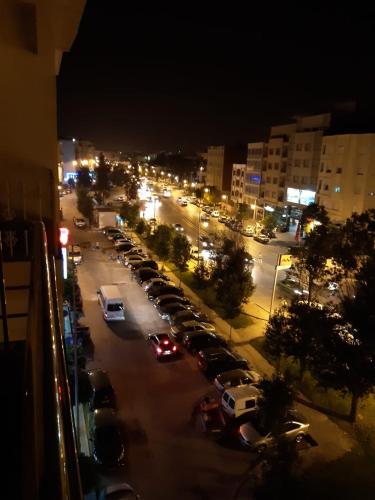 a city street with cars parked in a parking lot at night at Appartement Haut Standing Petit Déjeuner INCLUS in Tangier