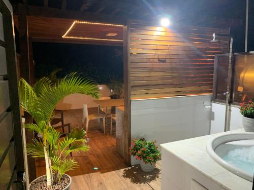 a bathroom with a tub and a sink and a table at Pipa Ubaia 219 com solarium in Pipa