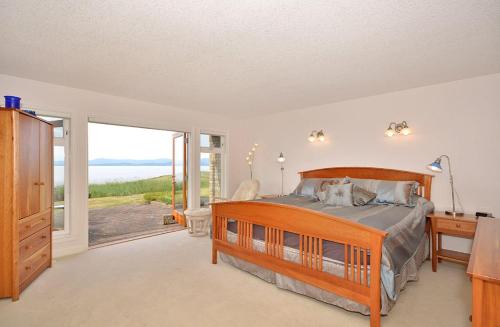 een slaapkamer met een bed en uitzicht op de oceaan bij Columbia Beach House in Parksville