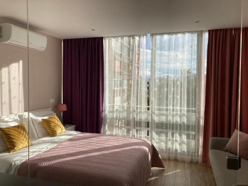 ein Schlafzimmer mit einem Bett und einem großen Fenster in der Unterkunft CASA JOY Vilamoura apartment in Vilamoura