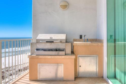 a kitchen with a grill and a balcony with the beach at Turquoise C702 in Orange Beach