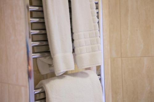 a towel rack with white towels in a bathroom at The Peel Aldergate in Tamworth