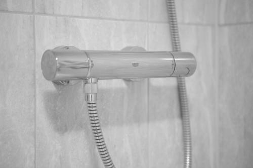 a shower head in a bathroom with a hose at The Peel Aldergate in Tamworth