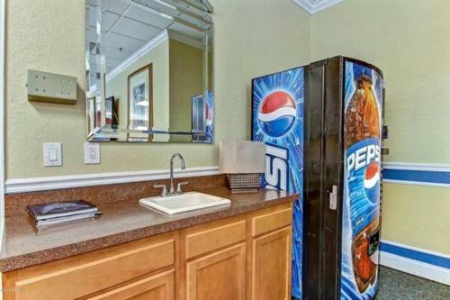 a bathroom with a pepsi cola refrigerator next to a sink at Cozy Downtown One Bedroom Condo Jacksonville in Jacksonville