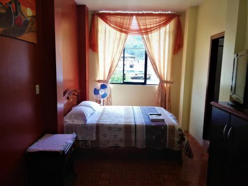 1 dormitorio con 1 cama frente a una ventana en Hostal Carolina, en Yantzaza