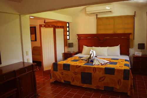 a bedroom with a bed with a yellow and blue comforter at Casa Kolping in Tuxtla Gutiérrez