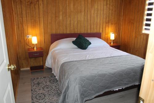 1 dormitorio con 1 cama con 2 lámparas en ambos lados en Anygus en Chile Chico