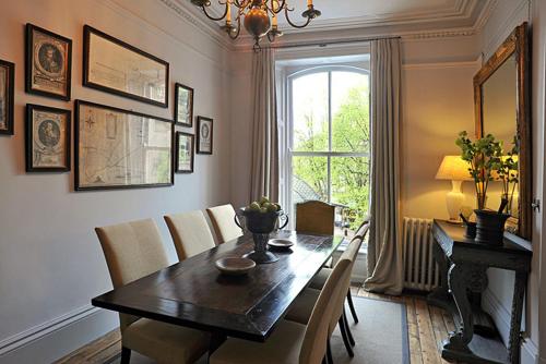 een eetkamer met een tafel en stoelen en een raam bij Royal Parade Apartments in Harrogate