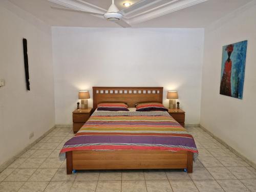 um quarto com uma cama e duas mesas de cabeceira em Tendinkoto Lodge em Sanyang