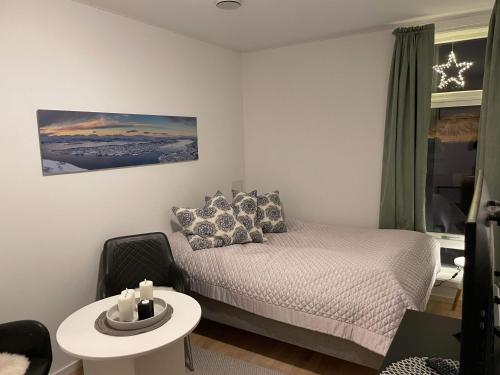 a small bedroom with a bed and a table at Studio Seaside in Tromsø