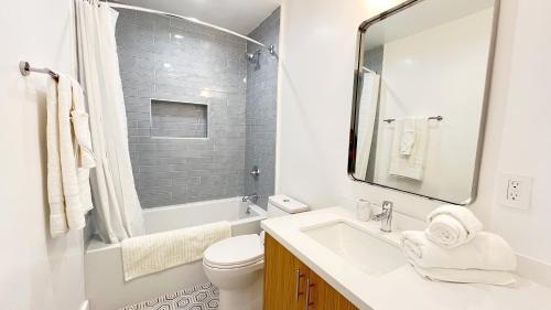 La salle de bains blanche est pourvue d'un lavabo et de toilettes. dans l'établissement Kingsley Courtyard Apartment, à Los Angeles
