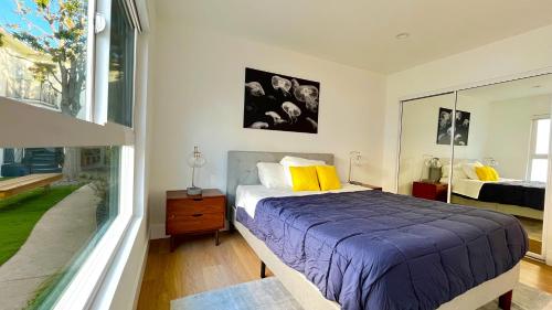 um quarto com uma cama e uma grande janela em Kingsley Courtyard Apartment em Los Angeles