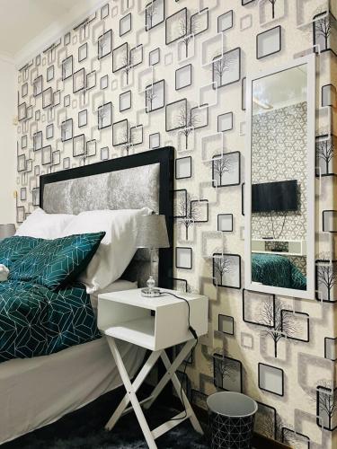 a bedroom with a bed and a mirror and a table at Q’s in Empangeni