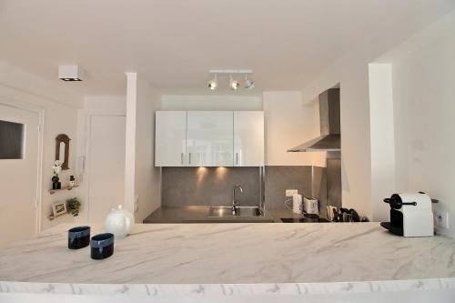 une cuisine avec un grand comptoir en marbre dans l'établissement CENTRAL CANNES, à Cannes