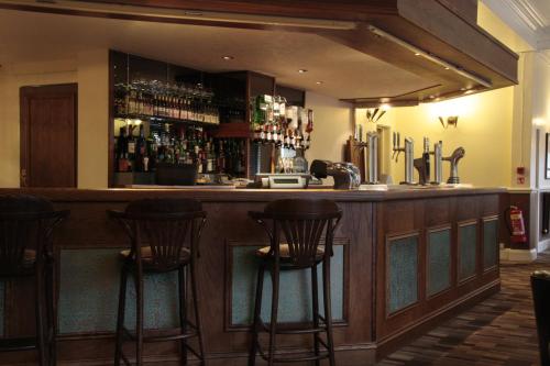 un bar con 4 taburetes en una habitación en Wortley House Hotel, en Scunthorpe