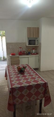a kitchen with a table with a red and white table cloth at Casa no Centro Bananeiras-PB in Bananeiras
