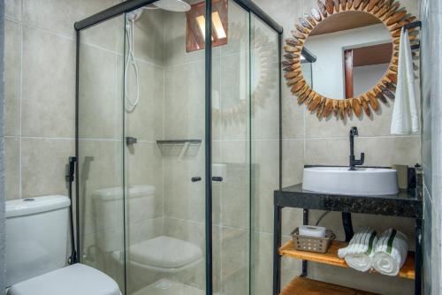 a bathroom with a shower and a toilet and a sink at Ubud Apartments Praia do Frances in Praia do Frances