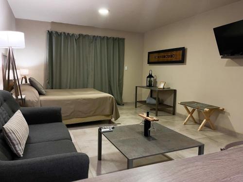 ein Wohnzimmer mit einem Bett, einem Sofa und einem Tisch in der Unterkunft Tres Cruces in Villa Unión