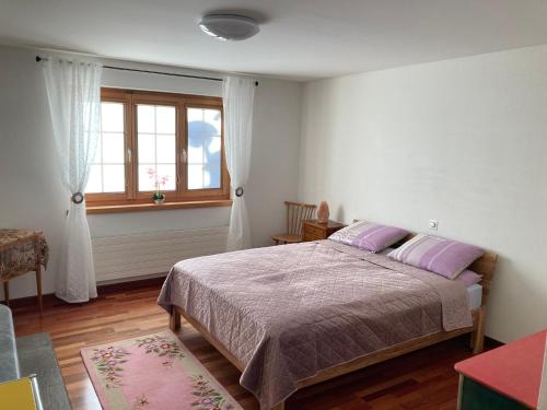 a bedroom with a bed with purple pillows and a window at Guardaval in Arosa