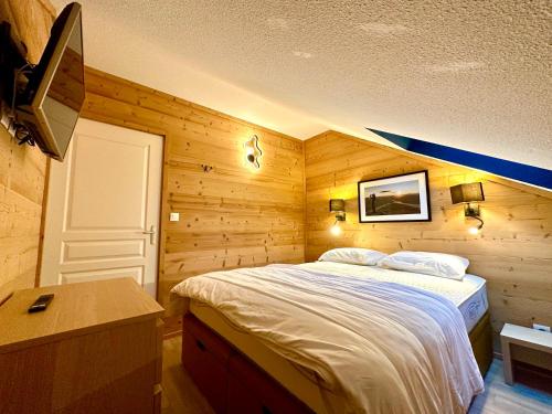 1 dormitorio con 1 cama grande en una habitación de madera en Duplex rénové - 2 chambres 7 personnes vue pistes en Les Orres