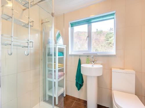 a bathroom with a sink and a shower and a toilet at Curin Cottage Strathconon in Contin