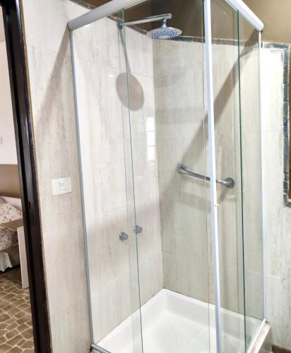 a shower with a glass enclosure in a bathroom at Posada Los Molles in Colón