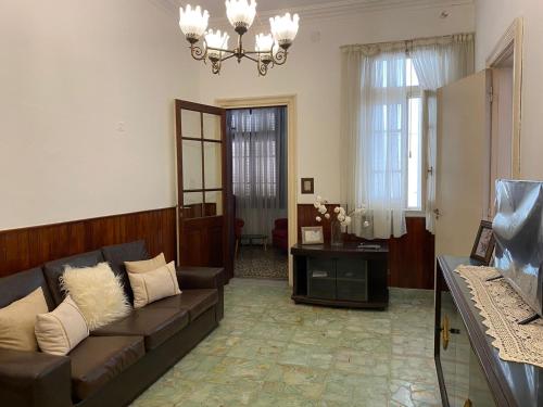sala de estar con sofá y lámpara de araña en Casa De Vacaciones Estilo Marplantense Temporada 2023 en Mar del Plata