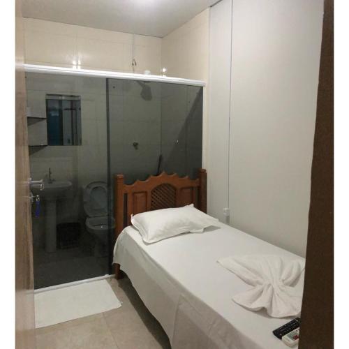 a bedroom with a bed and a bathroom with a shower at Hotel Cuiabá in Cuiabá