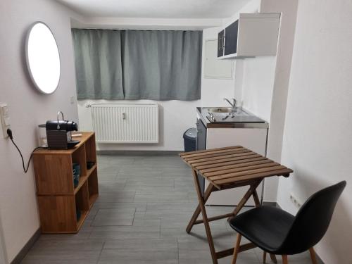 una pequeña cocina con una mesa de madera y una silla en Eco Apartment Cölbe, en Cölbe